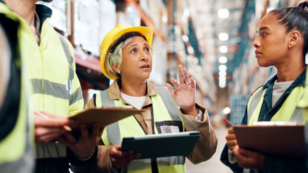 Distribution, tablet and team in warehouse, clipboard and conversation with planning for inventory. Group, manager and people in factory, tech and advice for inspection, logistics and quality checkの写真素材