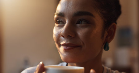 Daydreaming, smile and woman with coffee, morning and calm with caffeine on weekend, relax and peace. Home, thinking and person with cappuccino on break, reflection and contemplating with cup of teaの写真素材