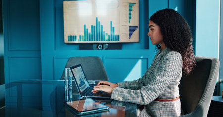 Business, woman and graph on laptop in office for finance review, data analysis and charts of growth. Female accountant, online and typing for financial report, profit statistics and company increaseの写真素材