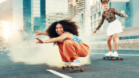 Skateboard, smoke and freedom with friends in city for gen z youth, streetwear fashion and balance. Fitness, energy and Happiness with women skating in street for riding, hobby and action togetherの写真素材
