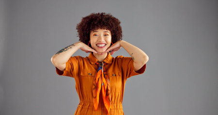 Happy, fashion and portrait of woman in studio with color, stylish and trendy clothing with confidence. Smile, mockup space and female person from Colombia with cool outfit by gray background.の写真素材