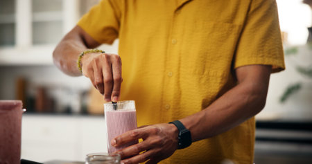 Man, hands and smoothie in kitchen for mixing, healthy diet or meal replacement recipe for wellness. Nutritionist, detox or drink in home for gut health, vitamin boost or supplement in protein shakeの写真素材