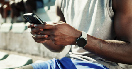 Athlete, hands and typing with phone and man in stadium for running performance, fitness stats and...