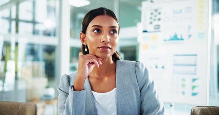 Woman, thinking and finance at office with smile for insight, solution and decision for review at company. Person, charts and perspective by board, problem solving and choice at accounting agencyの写真素材