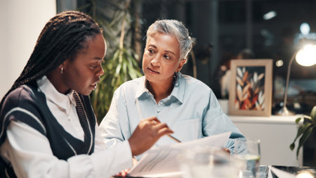 Documents, planning and business women in meeting for financial review, budget report and feedback. Corporate, office and workers with paperwork for collaboration, finance strategy and revenueの写真素材