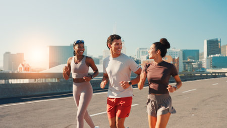 Happy people, fitness or running in city street for exercise, cardio workout or outdoor training. Active group, friends or runners with smile on road for physical health and wellness in an urban townの写真素材