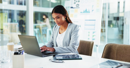 Business, woman and typing on laptop at desk for account management, finance report and budget proposal. Reading, accountant and technology for tax compliance, investment project and auditing reviewの写真素材