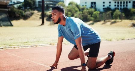 Ready, training and athlete or man on running track for fitness, sports and cardio performance. Health, marathon and runner with person and outdoor stadium for competition, start and workoutの写真素材