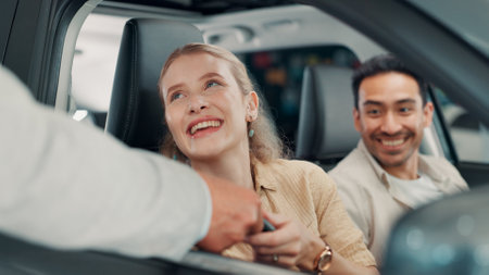 Keys, car or happy couple in showroom with salesman, smile or investment in auto insurance. Excited, people or buyer in dealership shopping for vehicle finance, customer satisfaction or motor salesの写真素材