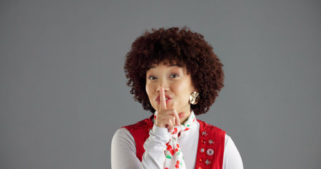 Portrait, woman or shush for secret in studio, gossip or confidential news on gray background. African person, quiet or hand gesture for silence, privacy or finger on lips for fashion on mockup spaceの写真素材