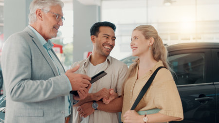 Excited, new car or couple in dealership with salesman, tablet or investment in auto insurance. Smile, retail or people in showroom shopping for vehicle report, customer satisfaction or motor salesの写真素材