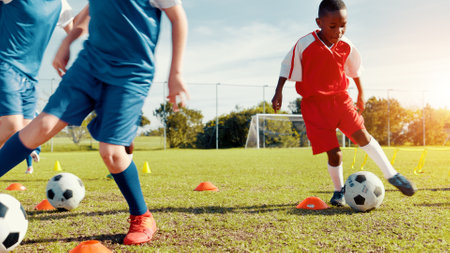 Outdoor, soccer player and children with ball, kick and athlete with energy for practice in morning. Sports field, football and kids with sportswear for game, growth and development with fitnessの写真素材