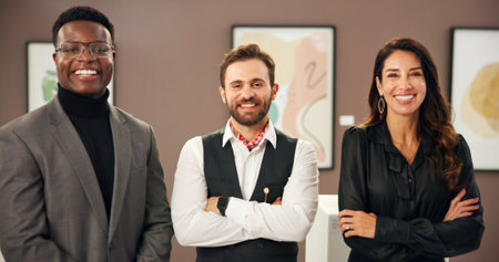 Happy, crossed arms and portrait of art dealers with teamwork, confidence and collaboration in showroom. Smile, creative career and group of gallery curators with frame paintings for display.の写真素材