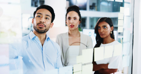 Glass wall, teamwork and business people in office, brainstorming and cooperation for social media project. Employees, feedback and PR agency with ideas, planning and support for proposal and reviewの写真素材