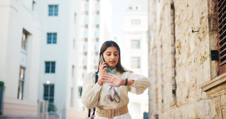 Business woman, phone call and watch in city for taxi, driver or stress for schedule on sidewalk. Person, smartphone and check clock on road for time management on commute, travel or trip in Mexicoの写真素材
