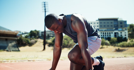 Start, workout and athlete or black man on race track for fitness, training and cardio performance. Health, marathon and sports runner with person and outdoor stadium for running, ready and eventの写真素材