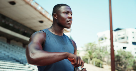 Thinking, black man and water bottle at stadium for fitness, planning and ideas for sports training. Athlete, male runner and thoughts with beverage for exercise, workout and performance for marathonの写真素材
