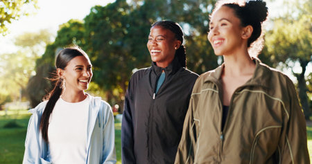 Laughing, women or athlete friends in park on break in outdoor training, workout or support in...