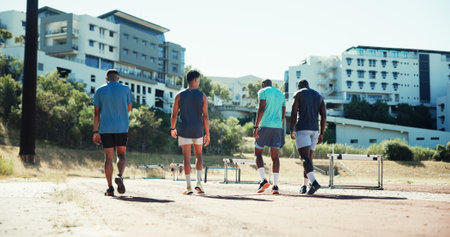 Men, track and group with hurdles, training and back with equipment, runner and exercise in summer. Team, people and athlete with workout, fitness and outdoor with support for sports competitionの写真素材