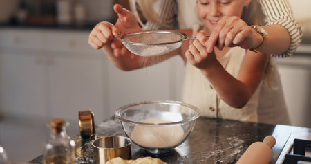 Baking, parent and child with ingredients in kitchen, teaching and helping for dessert or meal prep. Cooking, person and daughter with flour for culinary skills, growth and development of kid in homeの写真素材