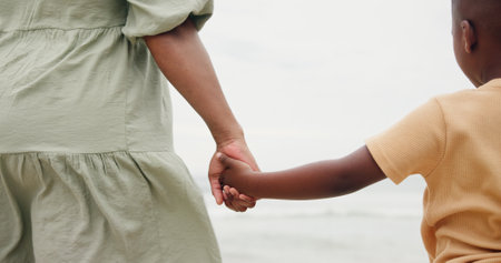 Holding hands, parent and child by ocean on vacation with care, love and bonding in nature. People, kid and support with connection, outdoor and holiday for family with back, beach and getaway by seaの写真素材