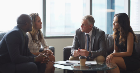 Meeting, office and business people in lobby with paperwork for contract deal. Professional, corporate and men with women in discussion with documents for planning, collaboration and partnershipの写真素材