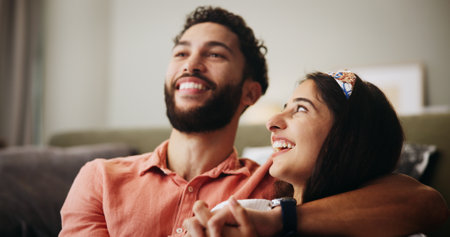 Hug, happy couple and comedy in living room with smile, bonding and weekend date in apartment. Embrace, man and woman with love in house for relationship, laugh or funny joke in home lounge for breakの写真素材