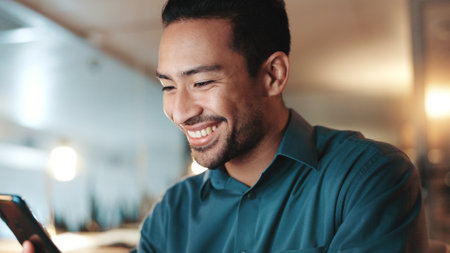 Happy, businessman and night with phone for communication, social media or network at office. Man, employee or user working late with smile on mobile smartphone for research, app or chat at workplaceの写真素材