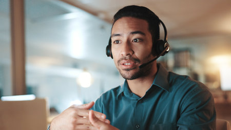 Communication, explain and headset with man in call center for assistance, help pr support at night. Computer, contact us and solution with person at office for online customer service in eveningの写真素材