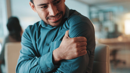 Frustrated, businessman and night with shoulder pain for muscle tension or discomfort at office. Man, employee or working late with sore arm, ache or injury for strain or bad posture at workplaceの写真素材