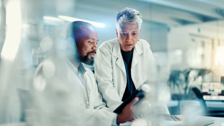 Discussion, scientists and team with tablet, lab or collaboration for medical research for analysis. Healthcare, science and mature people with tech for biotechnology, breakthrough and communicationの写真素材