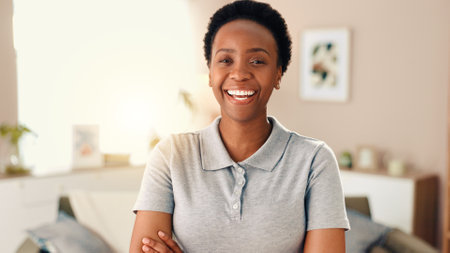 Black woman, portrait and happy with arms crossed in home, living room and confident with pride. African person, smile and excited for weekend, relax and face in morning at apartment in Nigeriaの写真素材