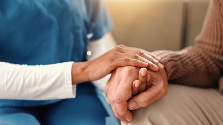 Holding hands, closeup and senior person with nurse on sofa for comfort, empathy and support....