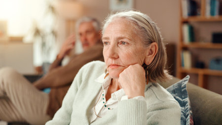 Frustrated, senior couple and fight with disagreement on sofa for toxic marriage at retirement home. Upset, elderly man or sad woman with argument for conflict, divorce or breakup at old age houseの写真素材