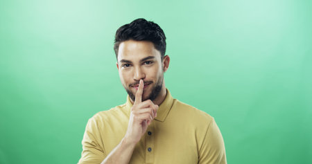 Portrait, man and shush for secret in studio for gossip, privacy sign and silence for rumor. Person,...