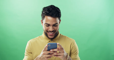 Man, phone and happy with texting in studio with notification, meme and laugh by green background....