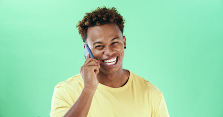 Black man, phone call and smile in studio portrait with laugh, funny chat and listen by green...