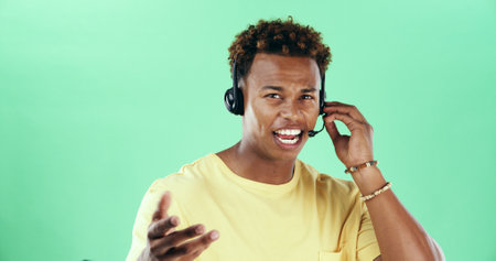 Portrait, headset and african man talking for call center, customer care and green background. Contact us, technical support and operator for help desk, advice and inquiry by mockup space in studioの写真素材