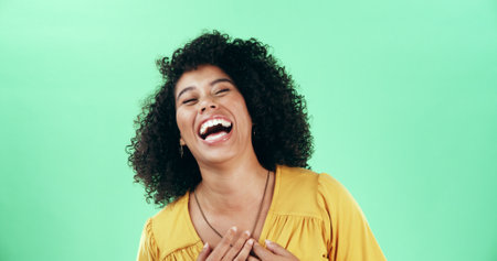 Studio, laughing and woman with humor, happiness and listening to funny joke, mockup space or comic. Green background, kindergarten teacher and person with smile for comedy, positive attitude and joyの写真素材