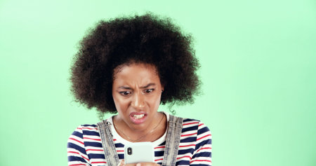 Green screen, phone or black woman with shock for breaking news, mockup and online scam. Space, stress and surprised African girl with mobile app for reading error, notification alert or studioの写真素材