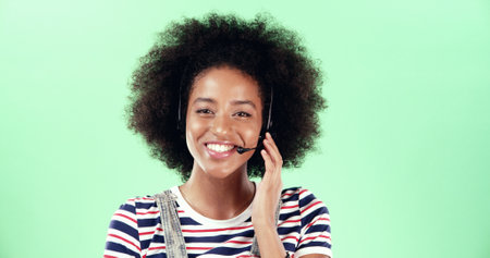 Black woman, portrait and call center microphone with headset for communication, customer support or help desk. Contact us, CRM or consultant in studio by space, smile and advice on green backgroundの写真素材