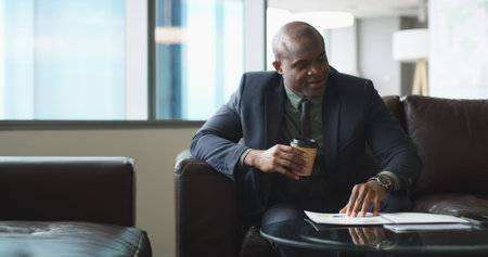 Office, coffee and black man with document for reading, investment report and accountant on sofa. Career, business person and financial advisor with paperwork for tax returns, review portfolio or teaの写真素材