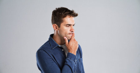 Thinking, man and confused with doubt in studio for fake news, problem solving or brainstorming....