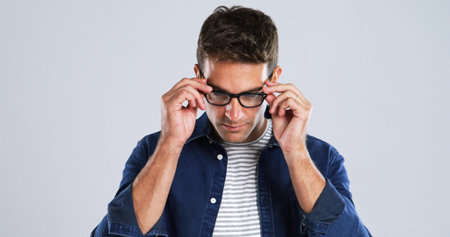 Man, glasses and touch in studio for vision, optometry or adjusting to new lens for sight. Person,...