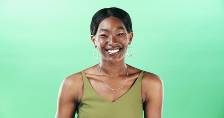 Laugh, green background and portrait of black woman in studio with confidence, smile and stylish. Fashion, space and face of isolated person with accessories for trendy clothes, outfit and aestheticの写真素材