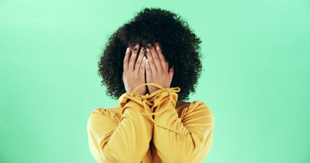Hands, covering and a shy woman in studio with embarrassment, mistake or disappointed emotion....
