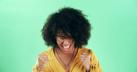 Studio, excited woman and fist pump to celebrate winning, goal achievement and victory. Success,...