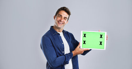 Green screen, tablet and portrait of man in studio for research, networking or social media. Happy, digital technology and male person with communication, email or contact by white background.の写真素材