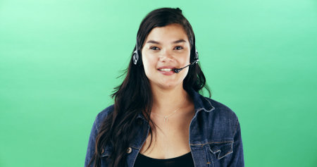 Headset, woman and portrait of call center agent in studio with confidence for customer care. Happy, pride and technical support consultant from Thailand with mic for contact us by green background.の写真素材