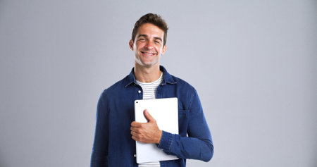 Portrait, smile and man with tablet in studio for about us, career pride and creative writing. Mockup space, happy and author with digital for article, blog and publishing story on white backgroundの写真素材